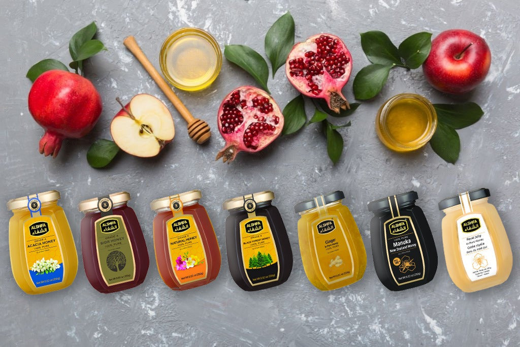 Assorted ALSHIFA honey jars with fresh fruit and honey dippers arranged on a stone surface