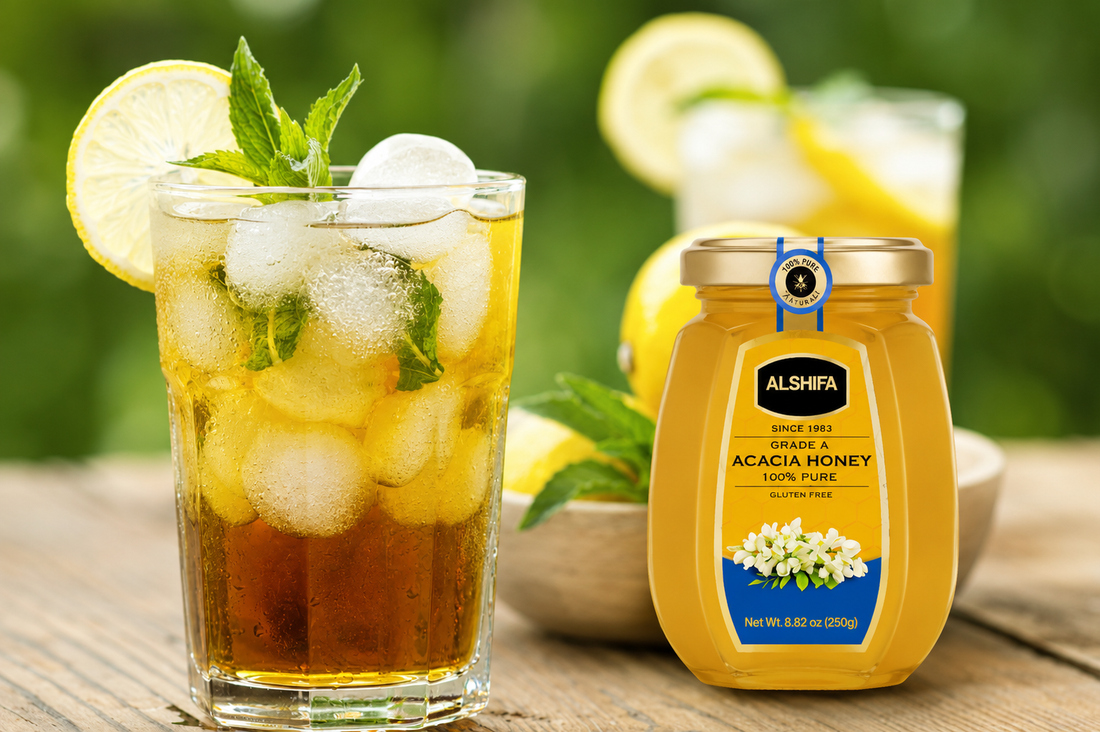 Glass of iced green tea with lemon and mint beside a jar of ALSHIFA Acacia Honey