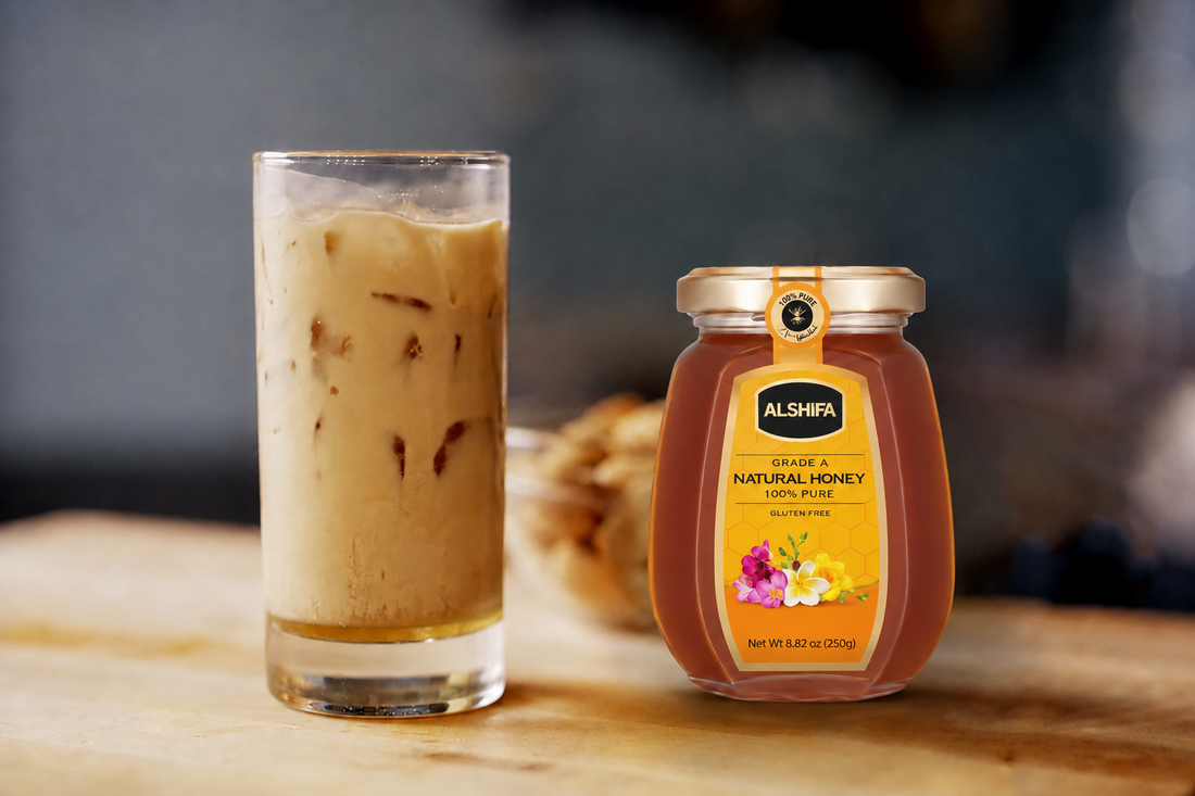 Tall glass of iced almond honey cold brew coffee beside a jar of ALSHIFA Natural Honey